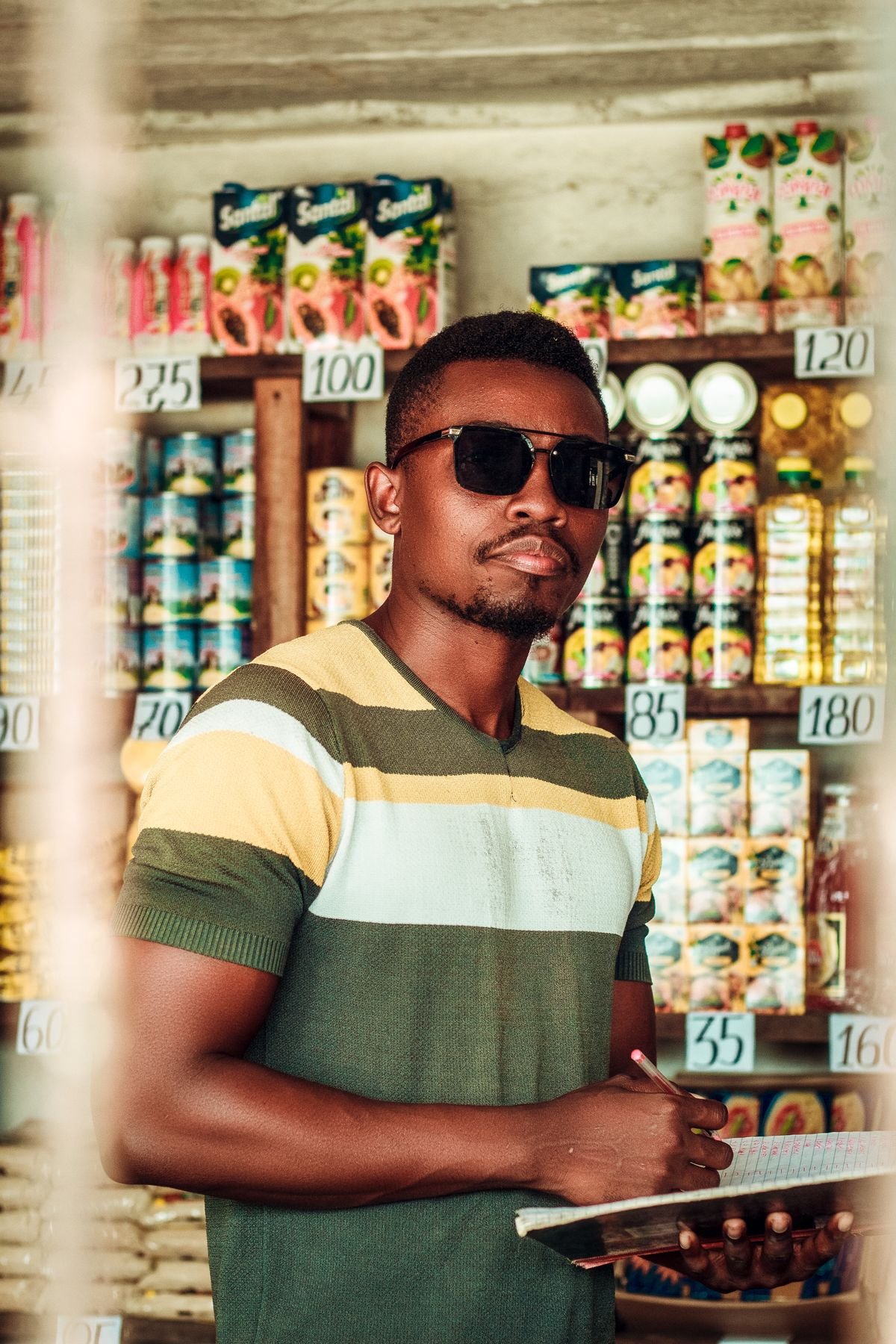 A retailer checking stock in a Nigerian trade shop